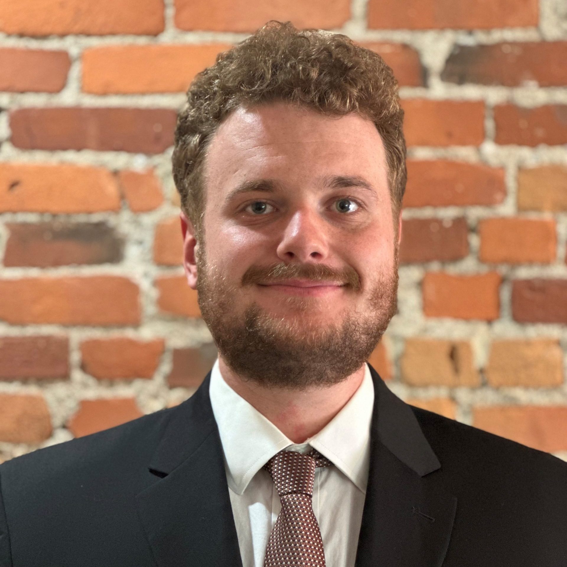 September 2025 Man smiling at camera wearing suit and tie
